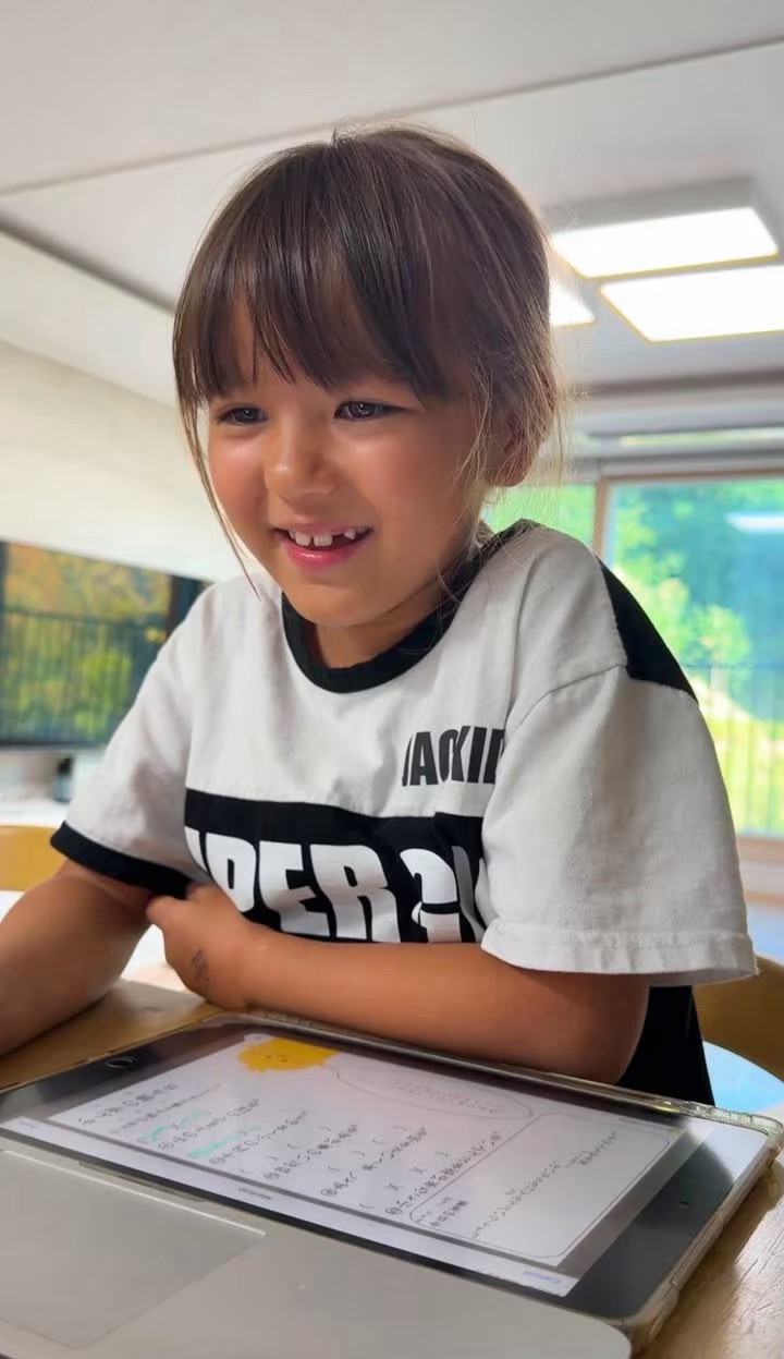 A smiling girl learning on a tablet