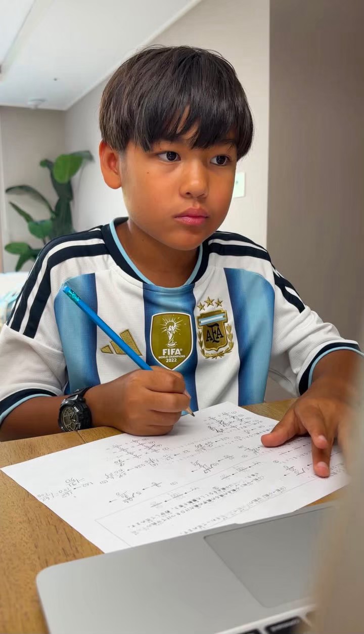A boy writing with a pencil